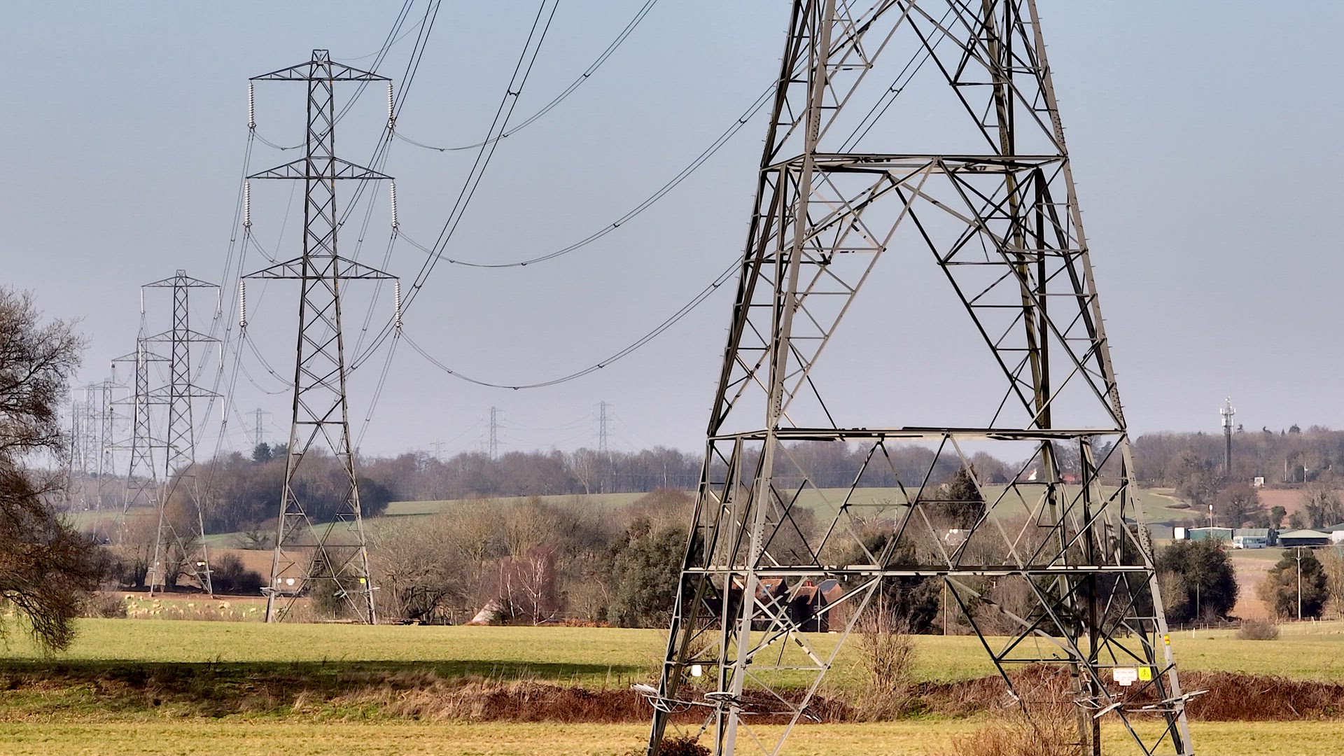 Rows of High Voltage Lattice Pylon Power Line Towers Aerial View
