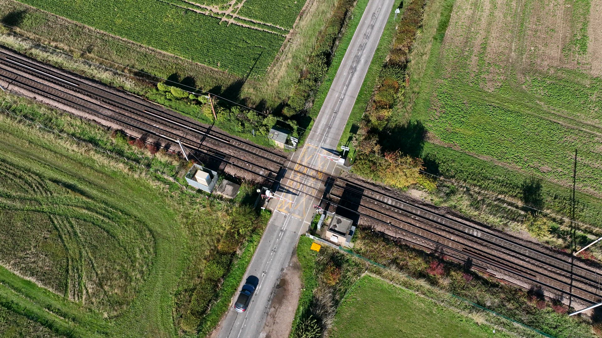 Cargo Train Passing Over a Level Crossing with Vehicles