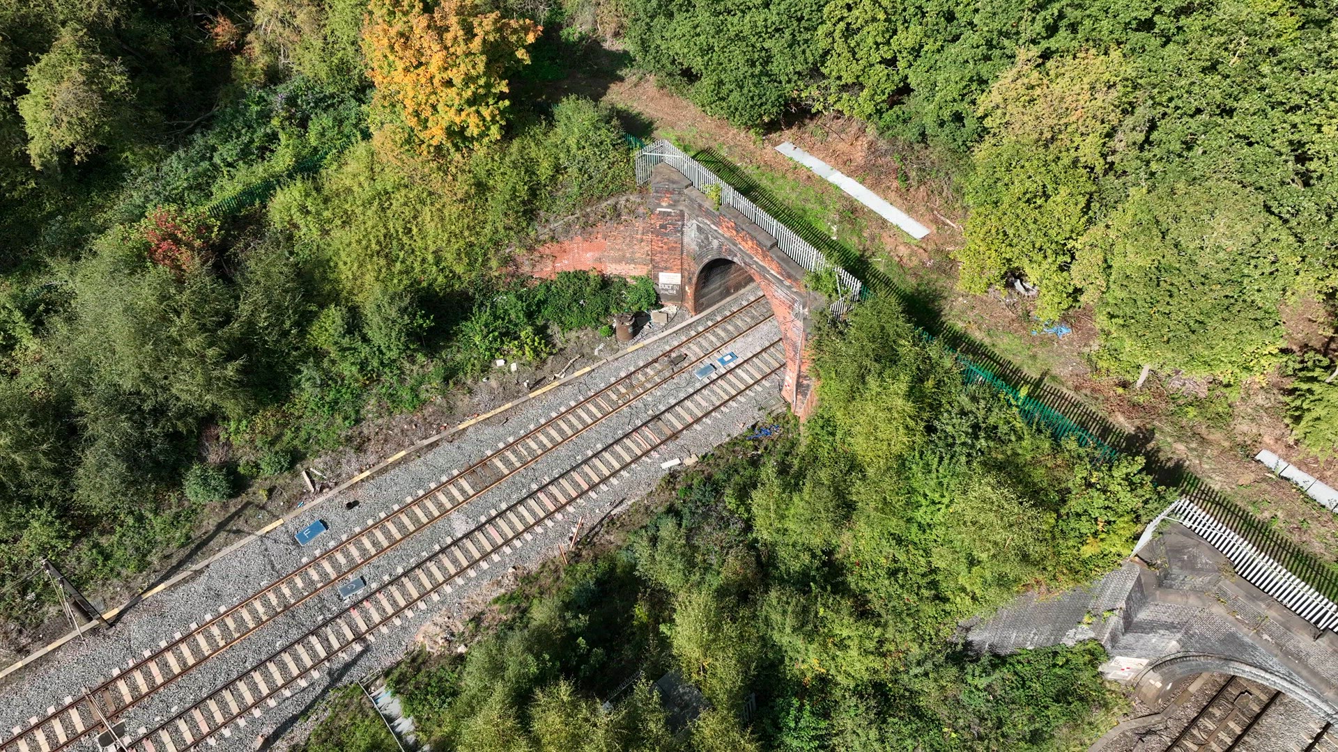 Commuter Train Exiting a Tunnel at High Speed Aerial View