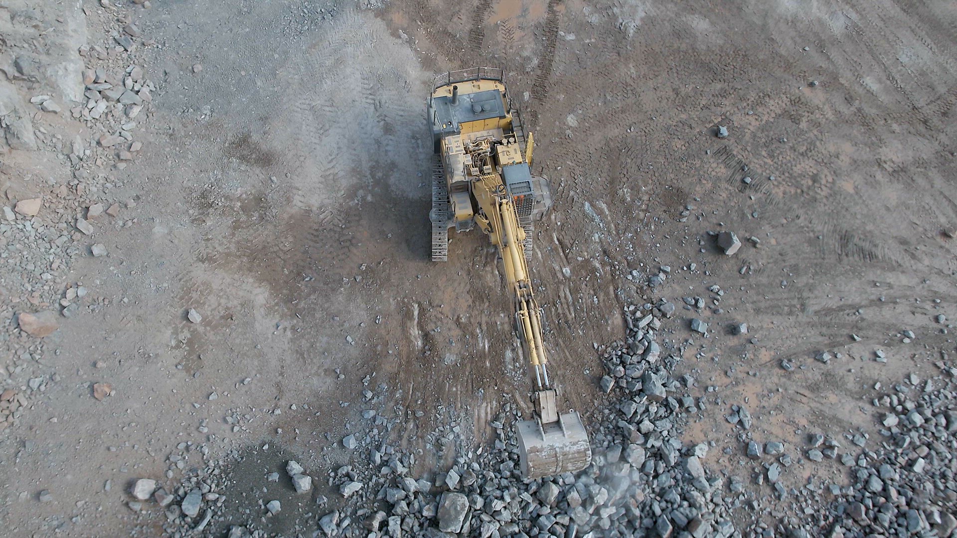 Digger Working on Blasted Rocks in a Quarry