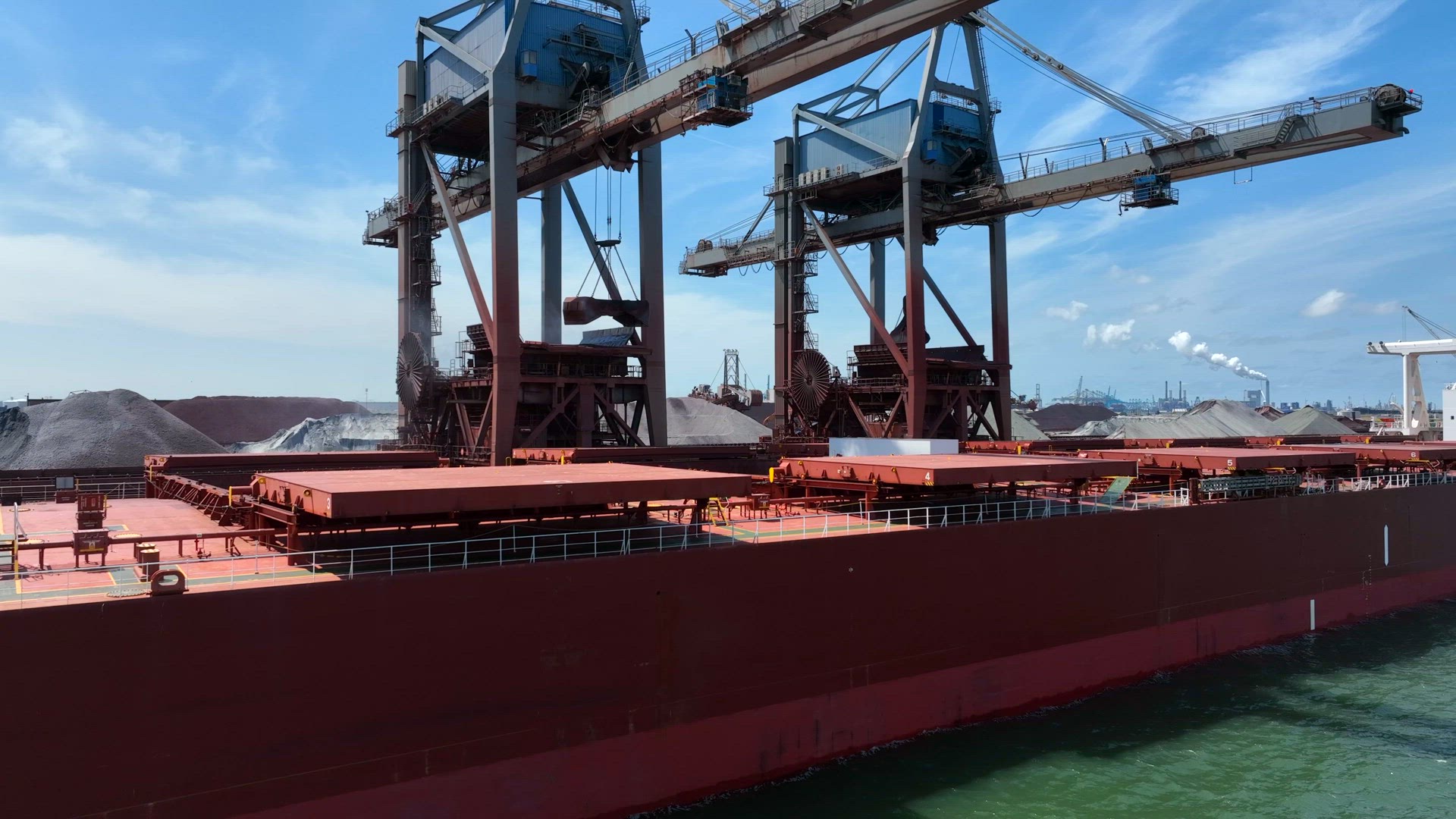 Cranes Unloading Commodities From a Bulk Carrier Ship at Port