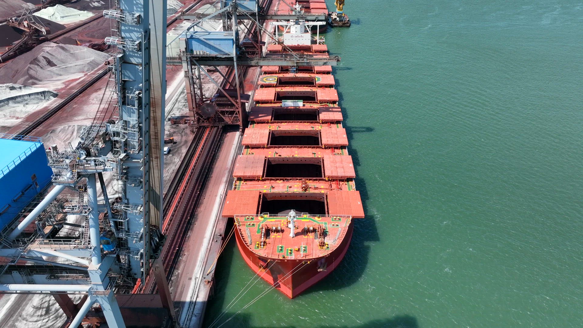 Cranes Unloading Commodities From a Bulk Carrier Ship at Port
