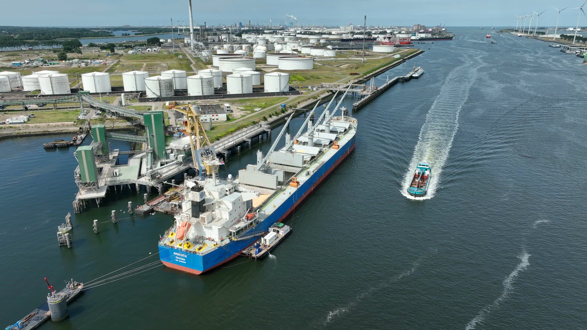 Bulk Carrier Ship at Port Offloading Cargo and Commodities