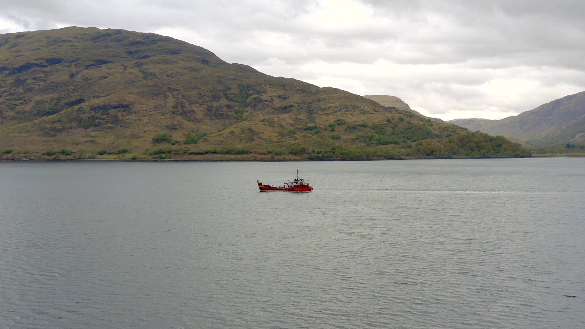 A Commercial Ship is Seen Traversing A Sea Loch in Scotland