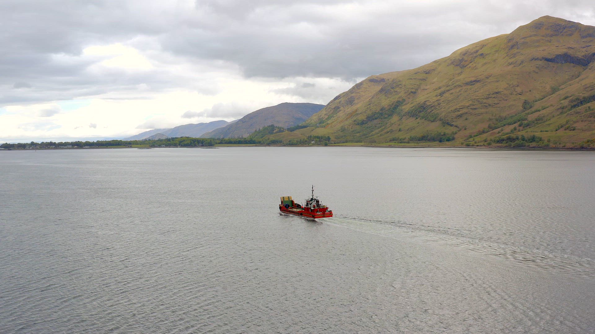 A Commercial Ship is Seen Traversing A Sea Loch in Scotland