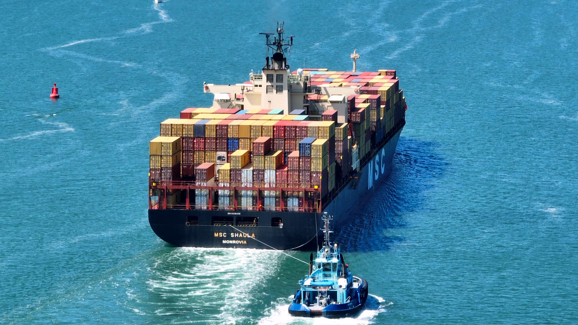 A Container Vessel Being Assisted into Port By a Tug Boat