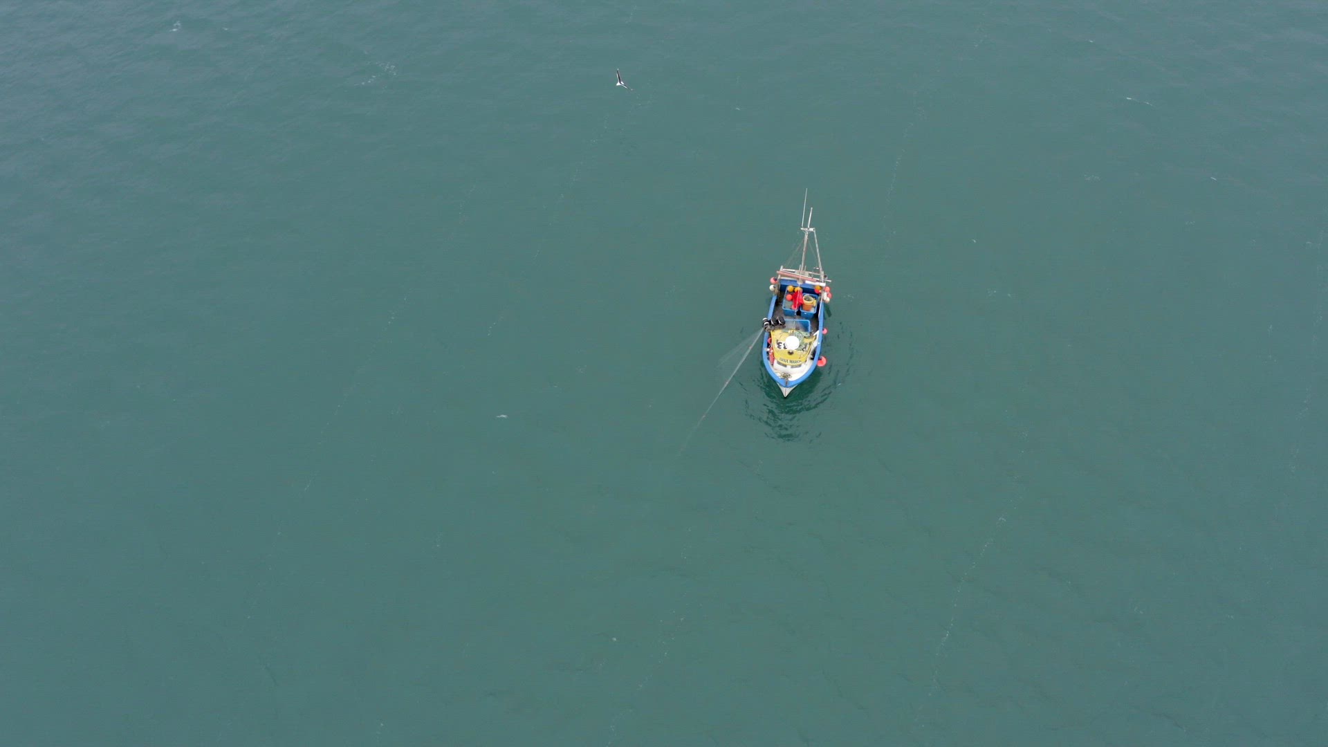 Fishing Crew Pulling Nets on a Small Boat at Sea