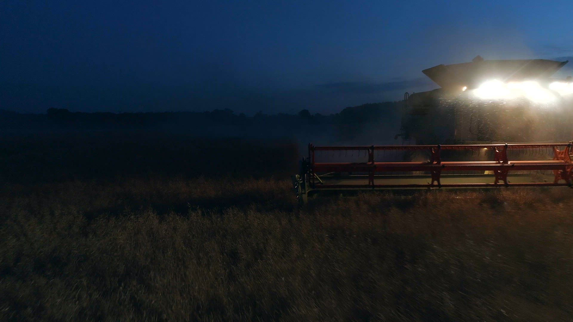 Combine Harvester Working At Night During Harvest Time