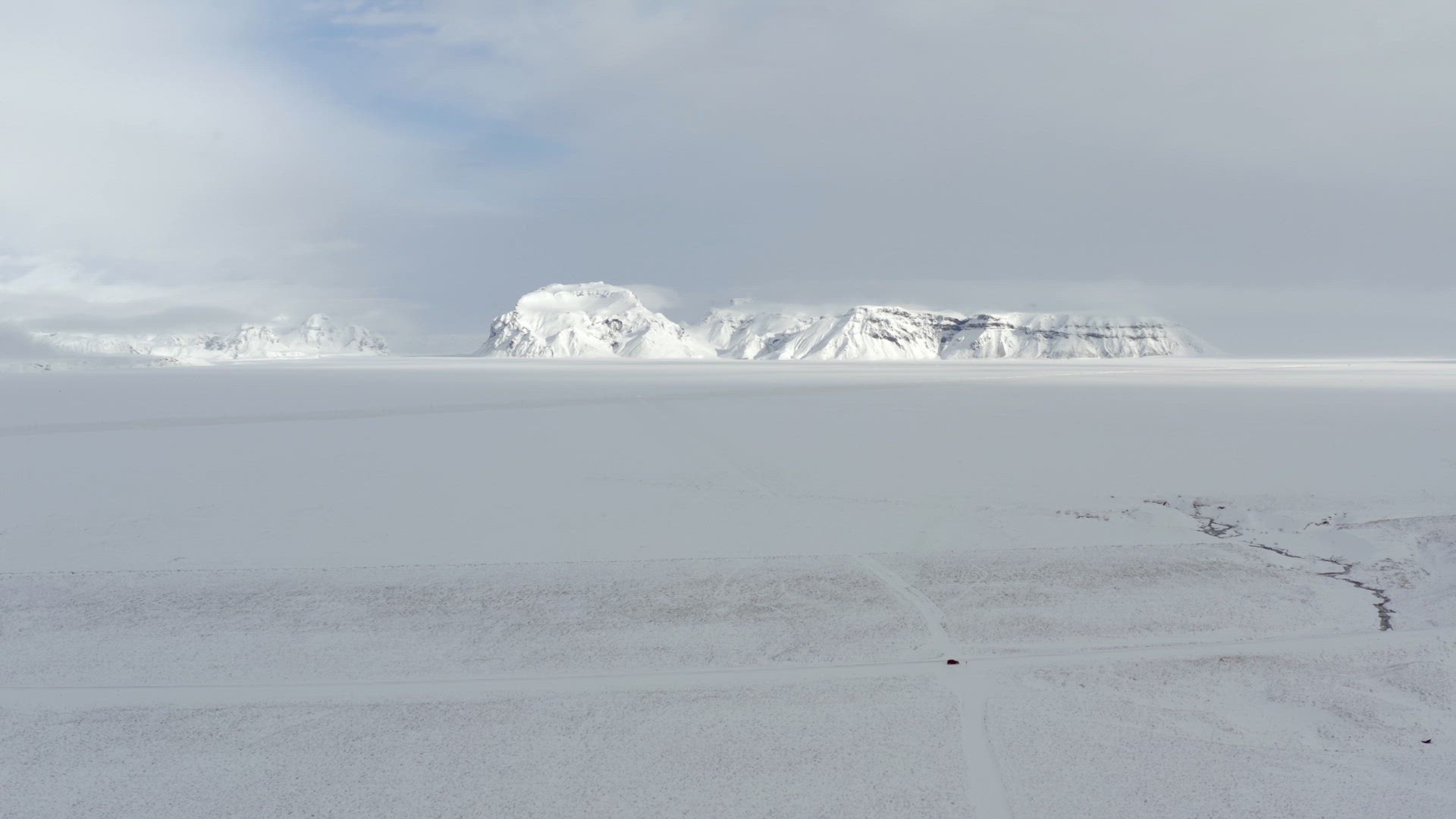 Distant Mountain Across a Lava Field in Iceland Covered in Snow