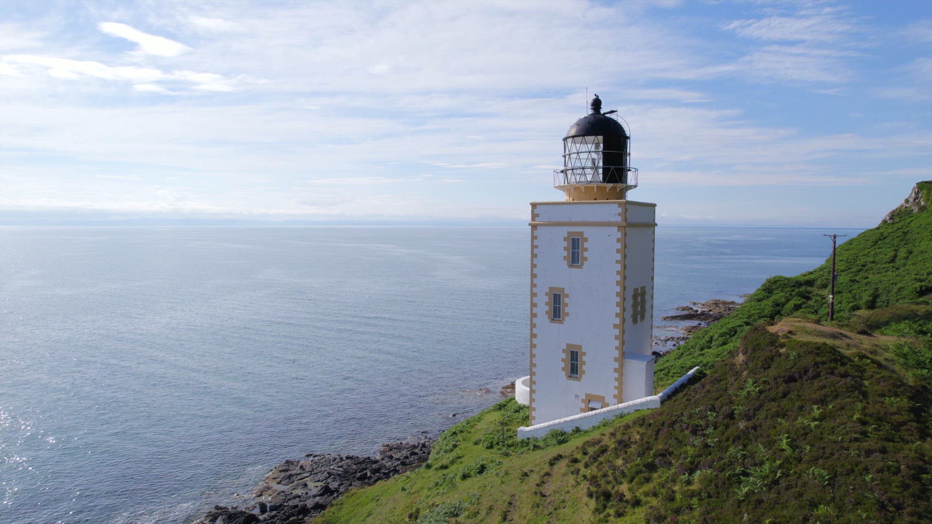 A Beautiful Square Lighthouse on a Cliff in the Summer