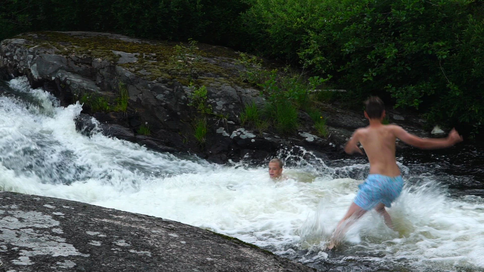 boys playing in waterfall - jumping into water - slomo.mp4