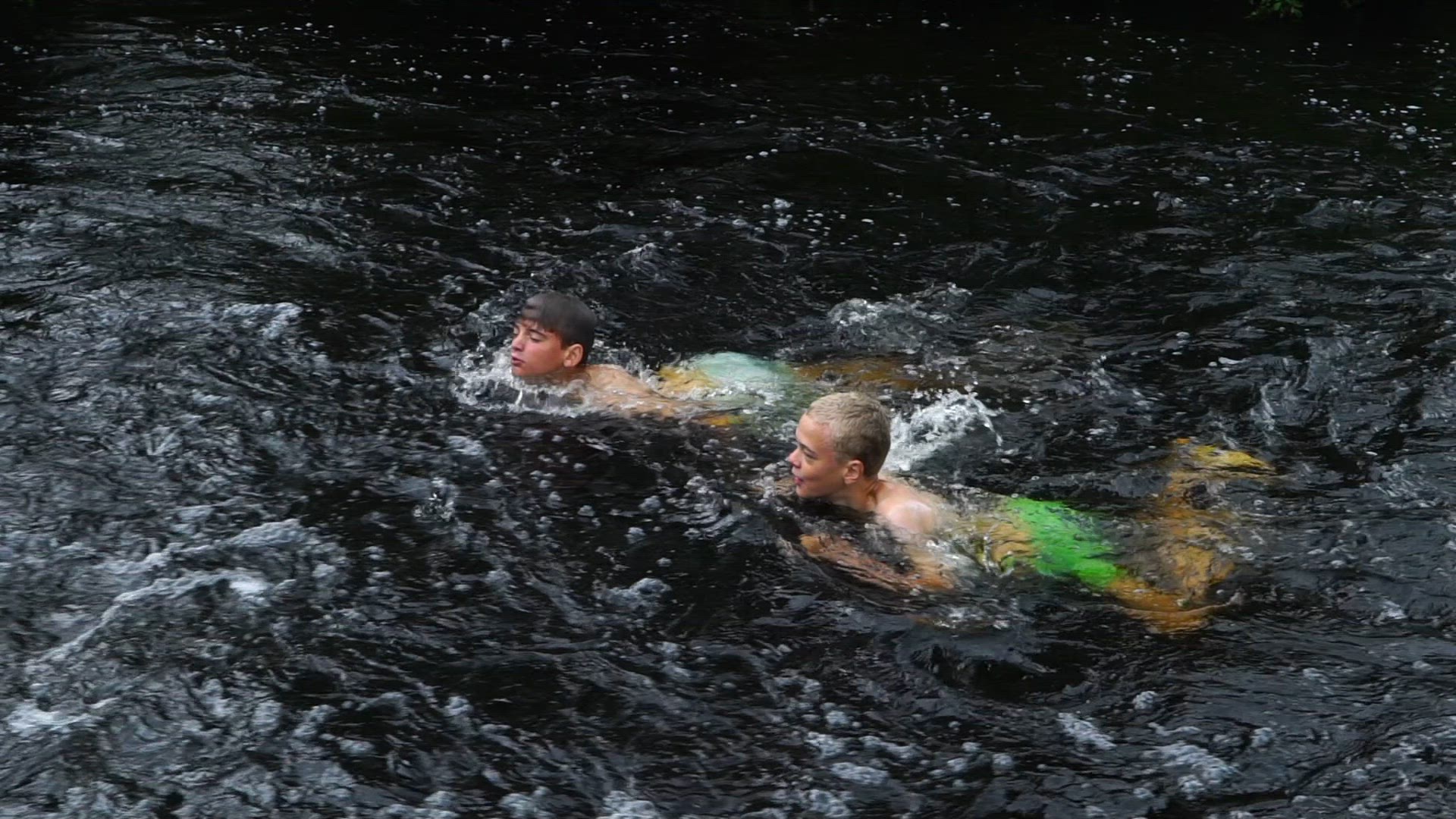 boys swimming in river - slowmotion - upstream.mp4