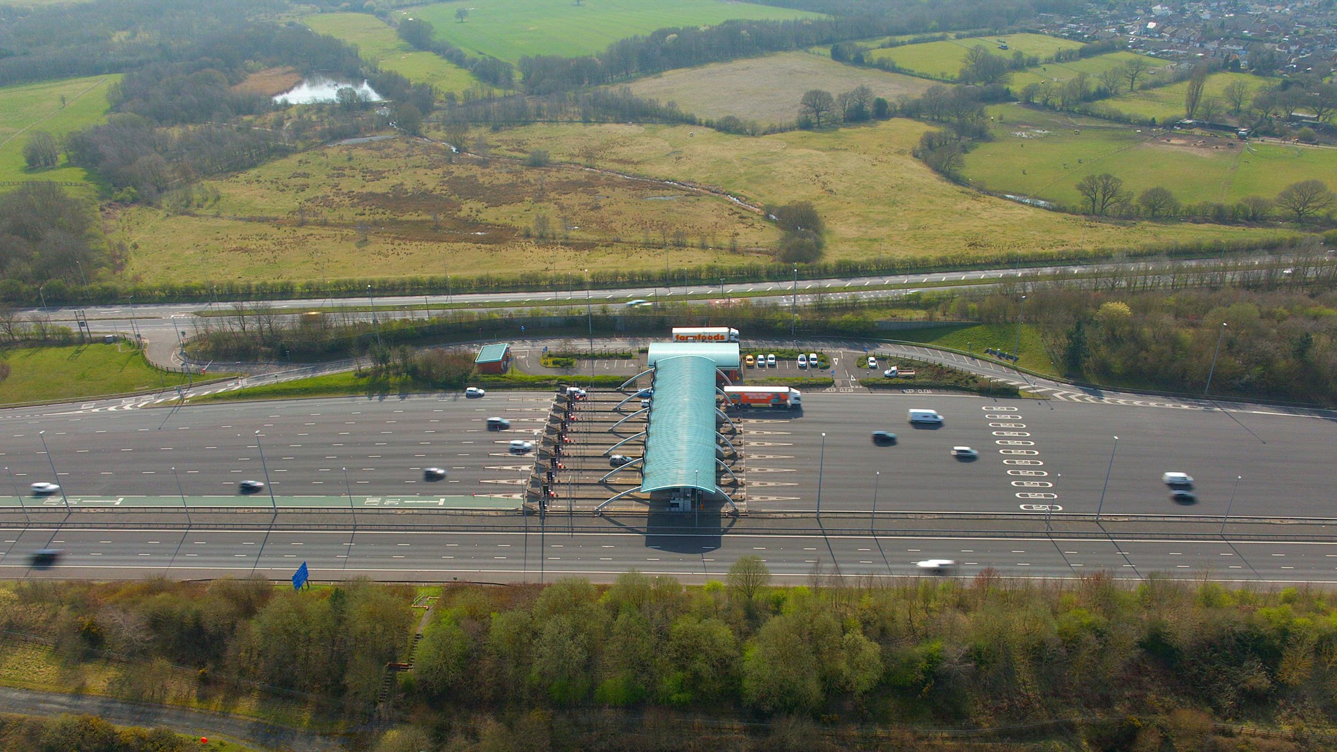 Vehicles Driving Through Toll Booths on a Motorway Aerial Time Lapse