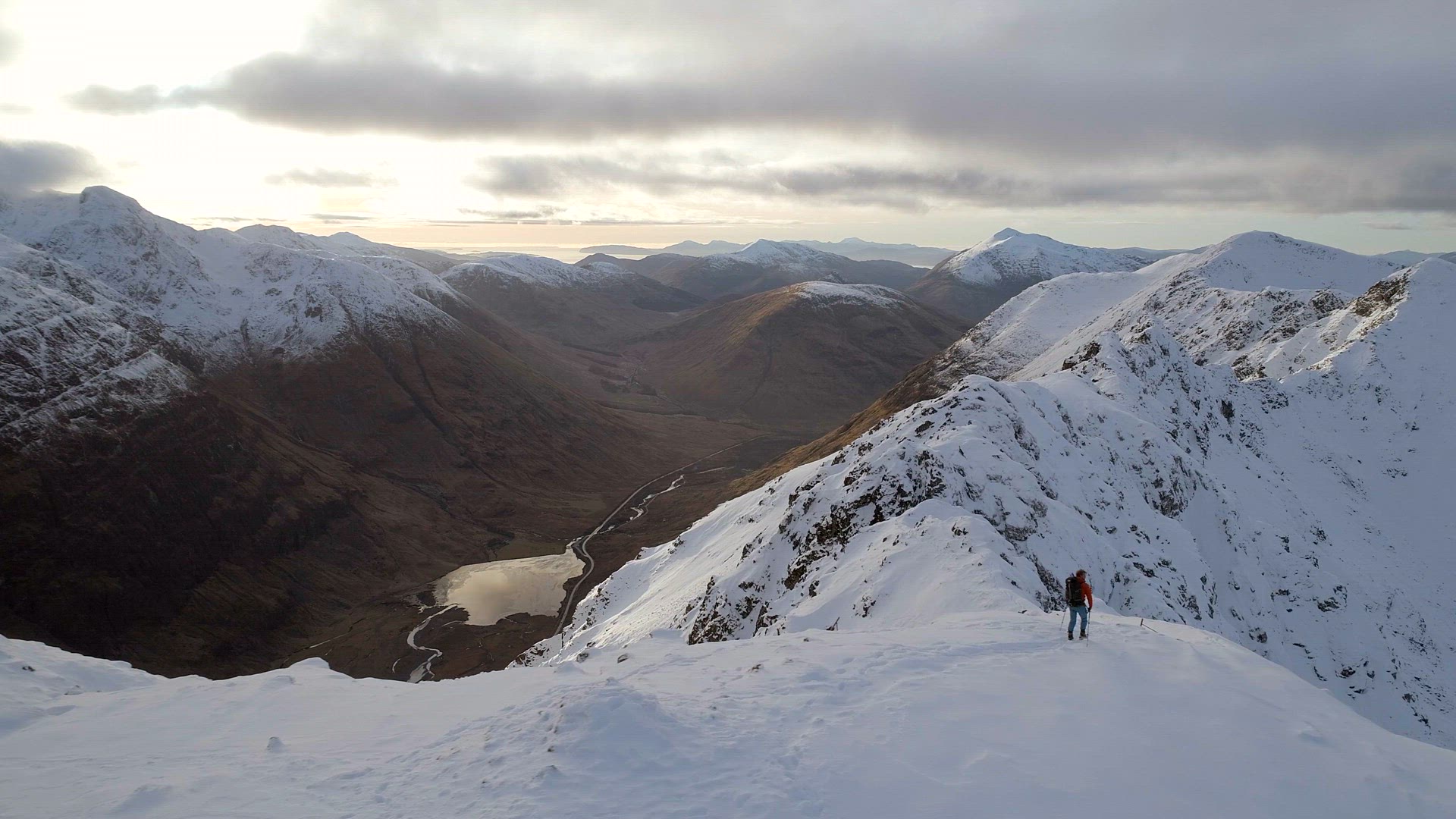 Mountain Climber at the Summit of a Mountain About to Traverse a Pass