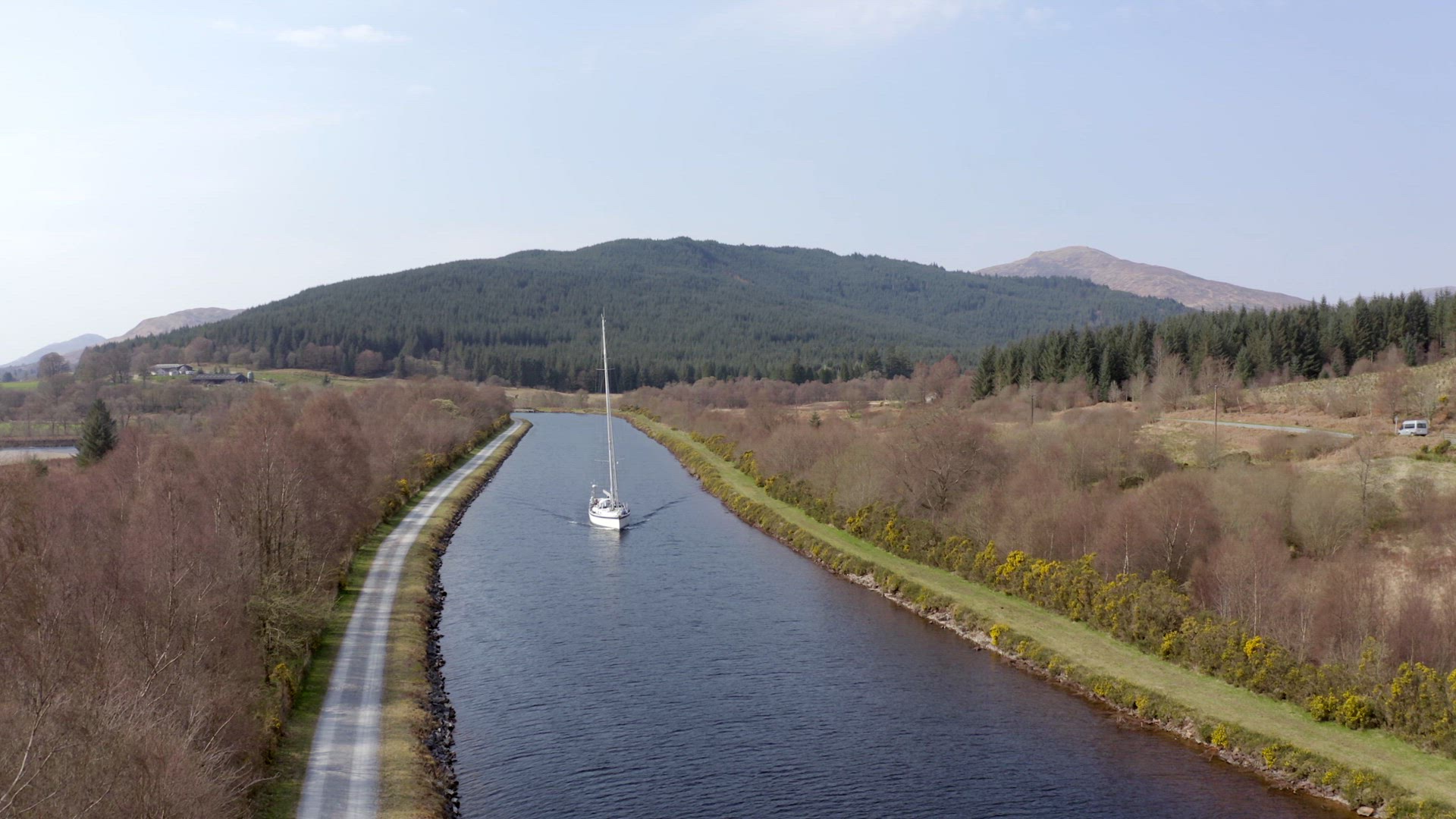 A Luxury Sailing Yacht Motoring Along a Canal