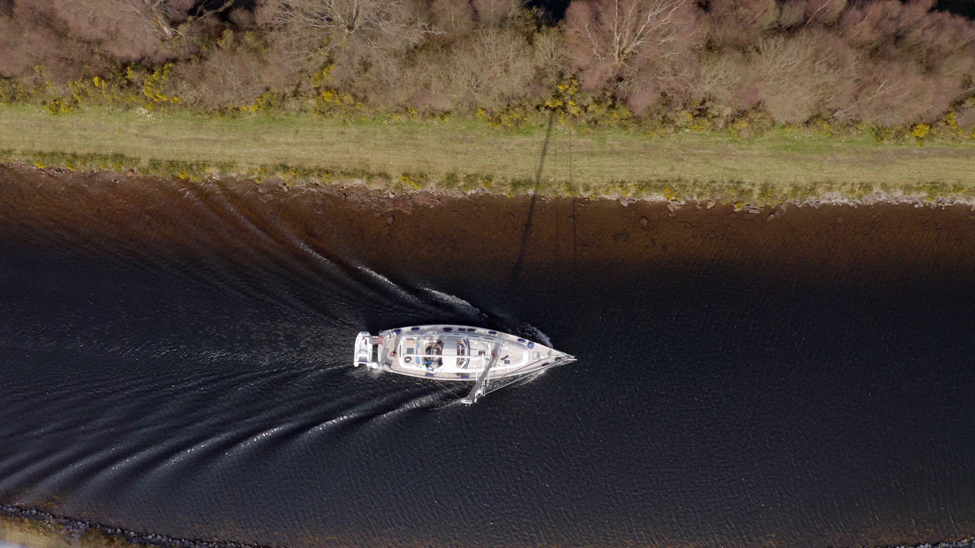A Sailing Yacht Motoring Along a Canal Bird's Eye View