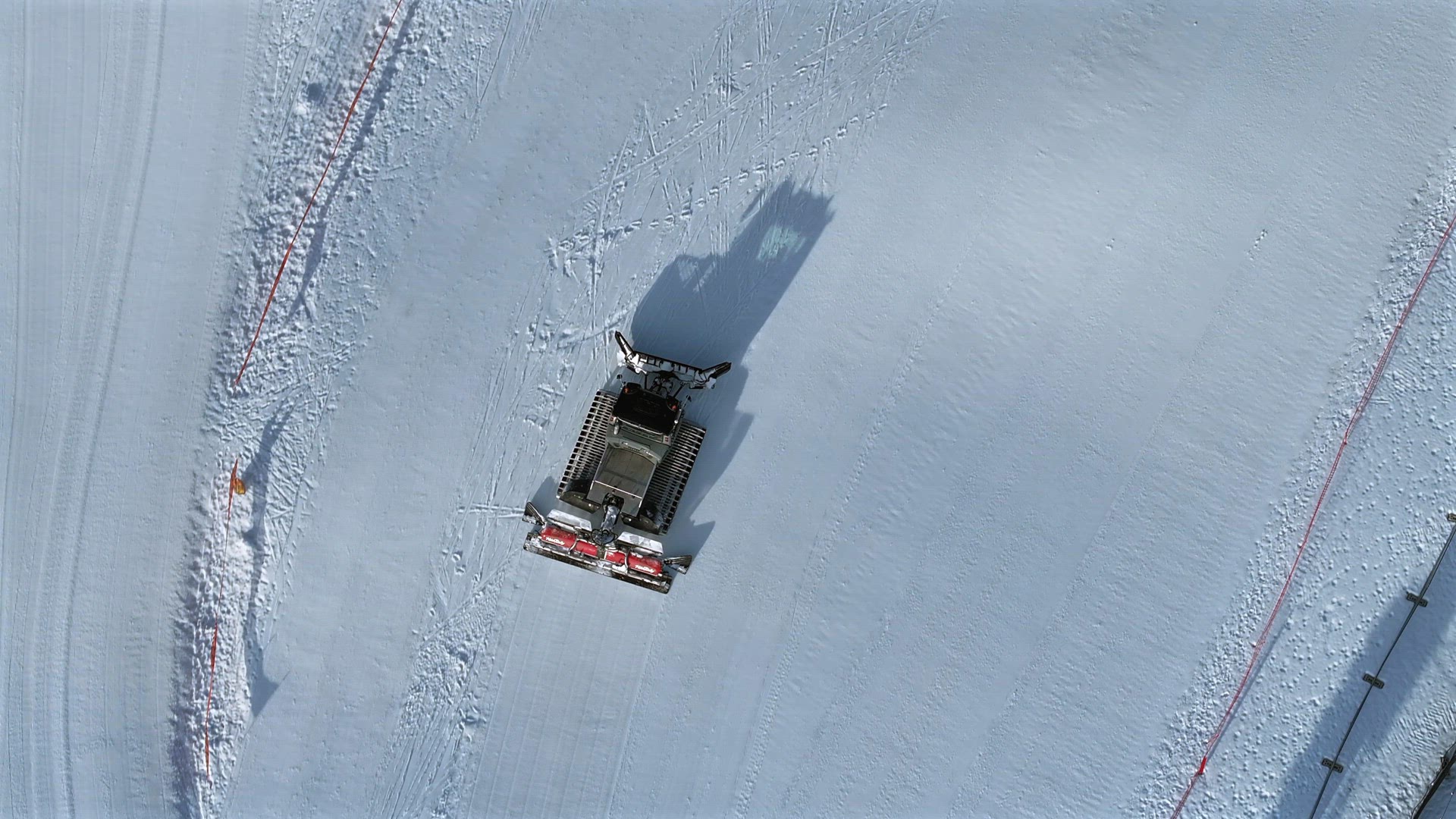 Snow Groomer Machine Working on a Ski Piste Aerial View