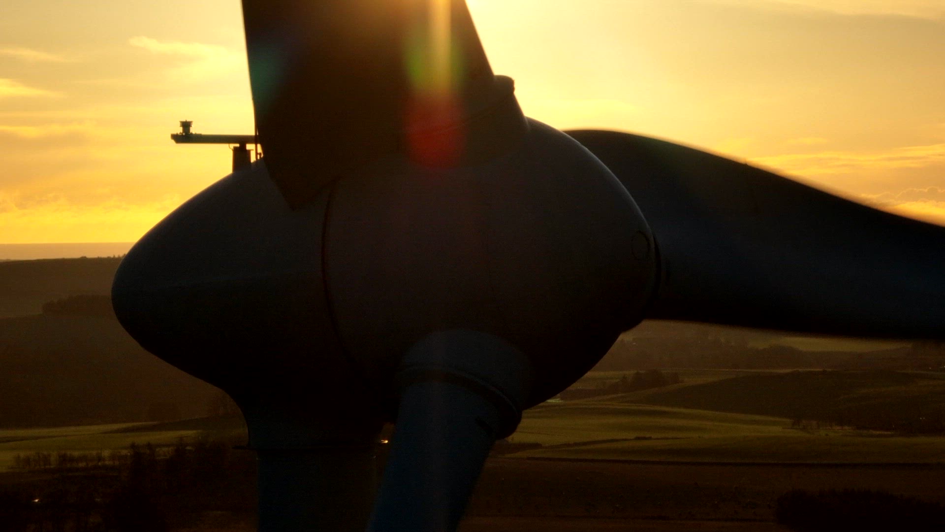 Wind Turbine Silhouette at Sunset Generating Renewable Energy