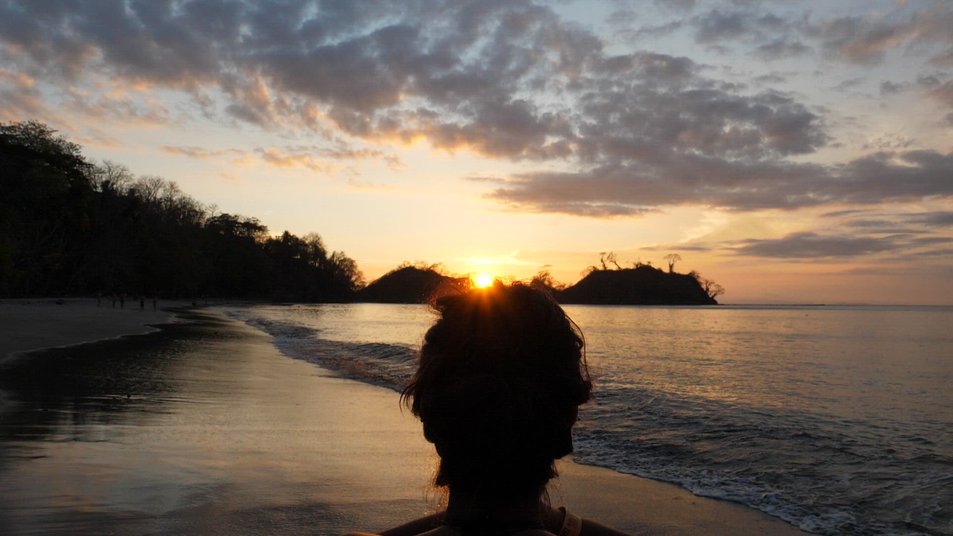 Young girl practicing yoga on the beach at sunset