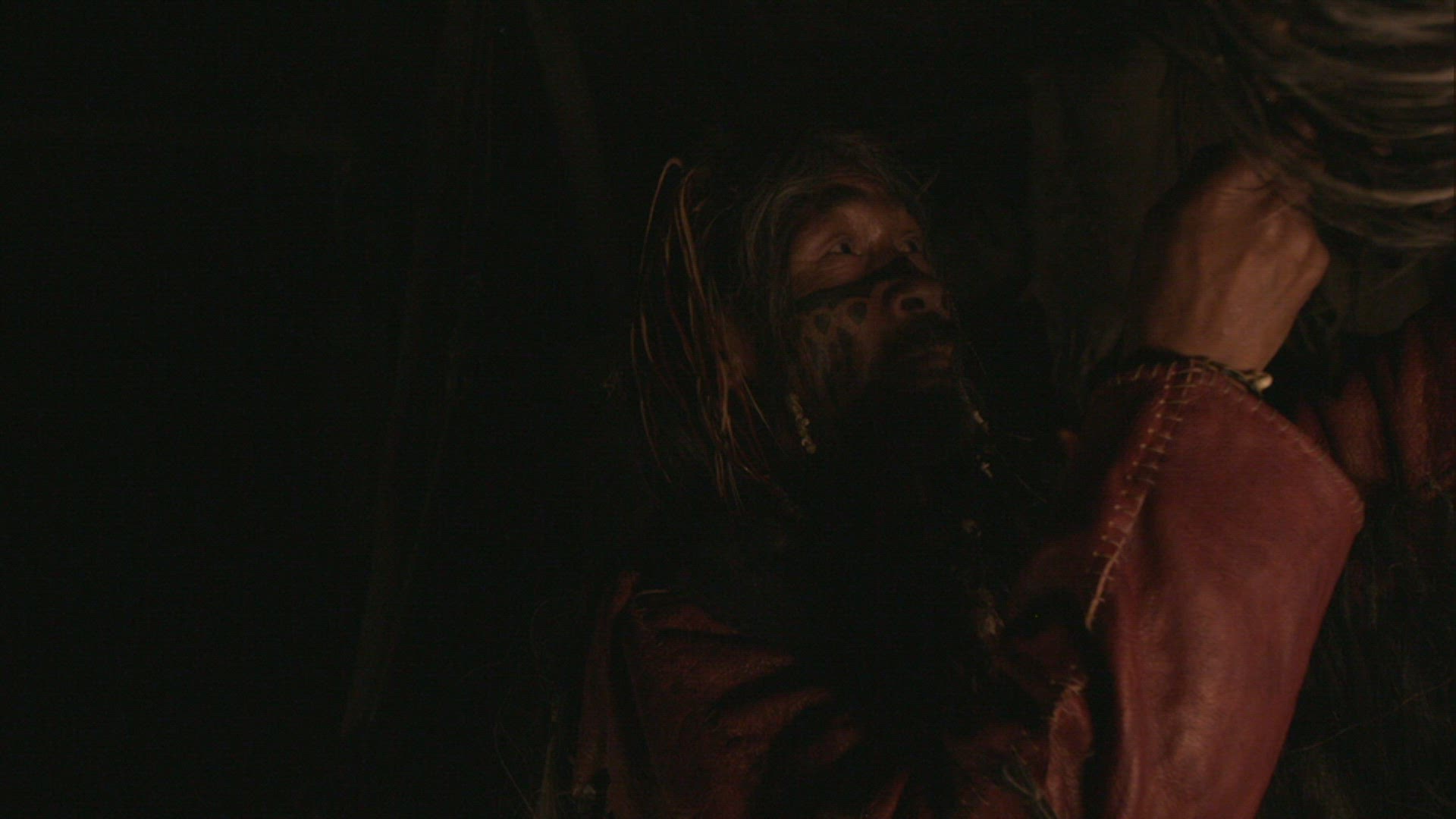 nomadic hunter inside hut playing drum