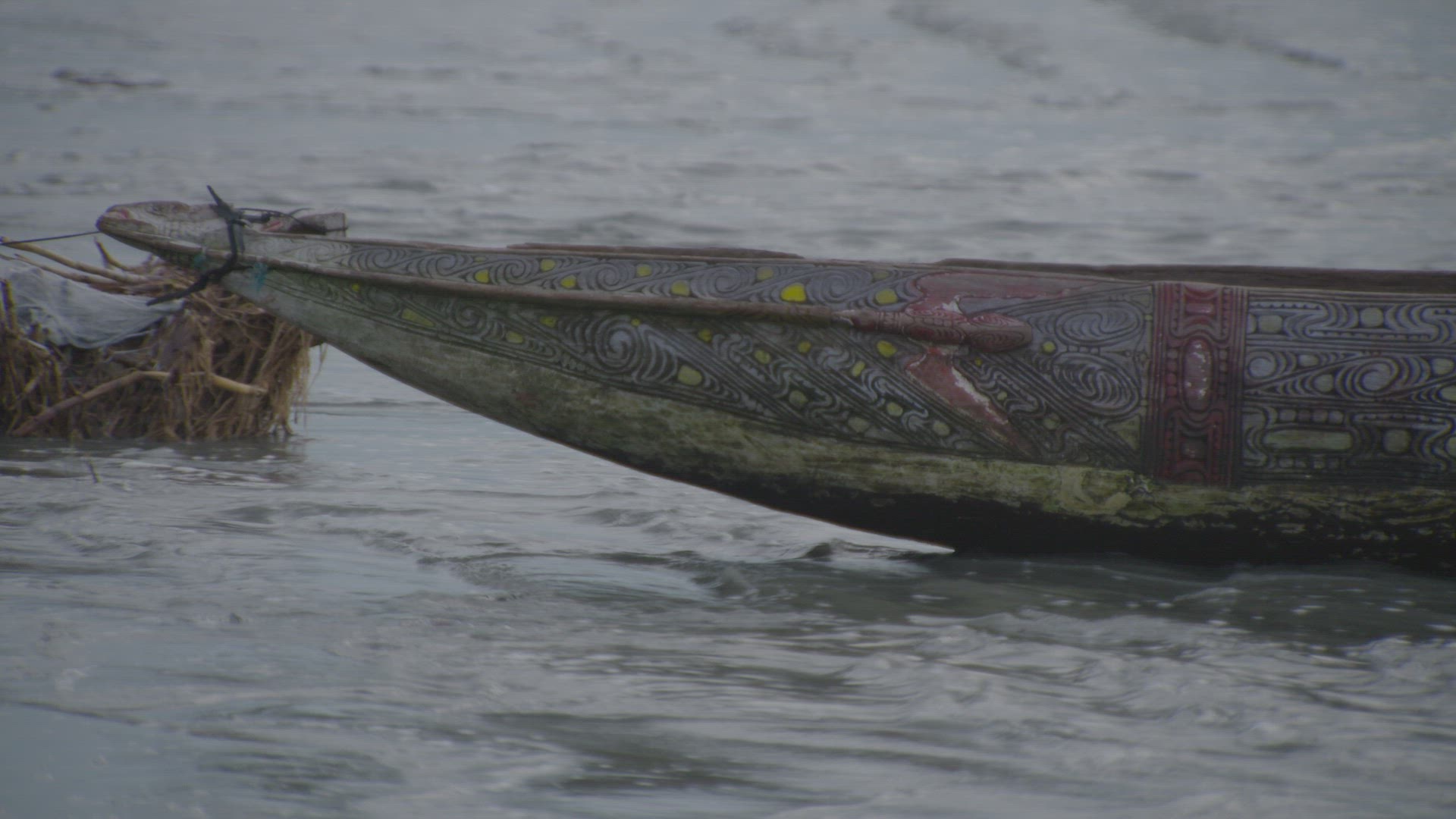 painted detail of hand carved wooden canoe