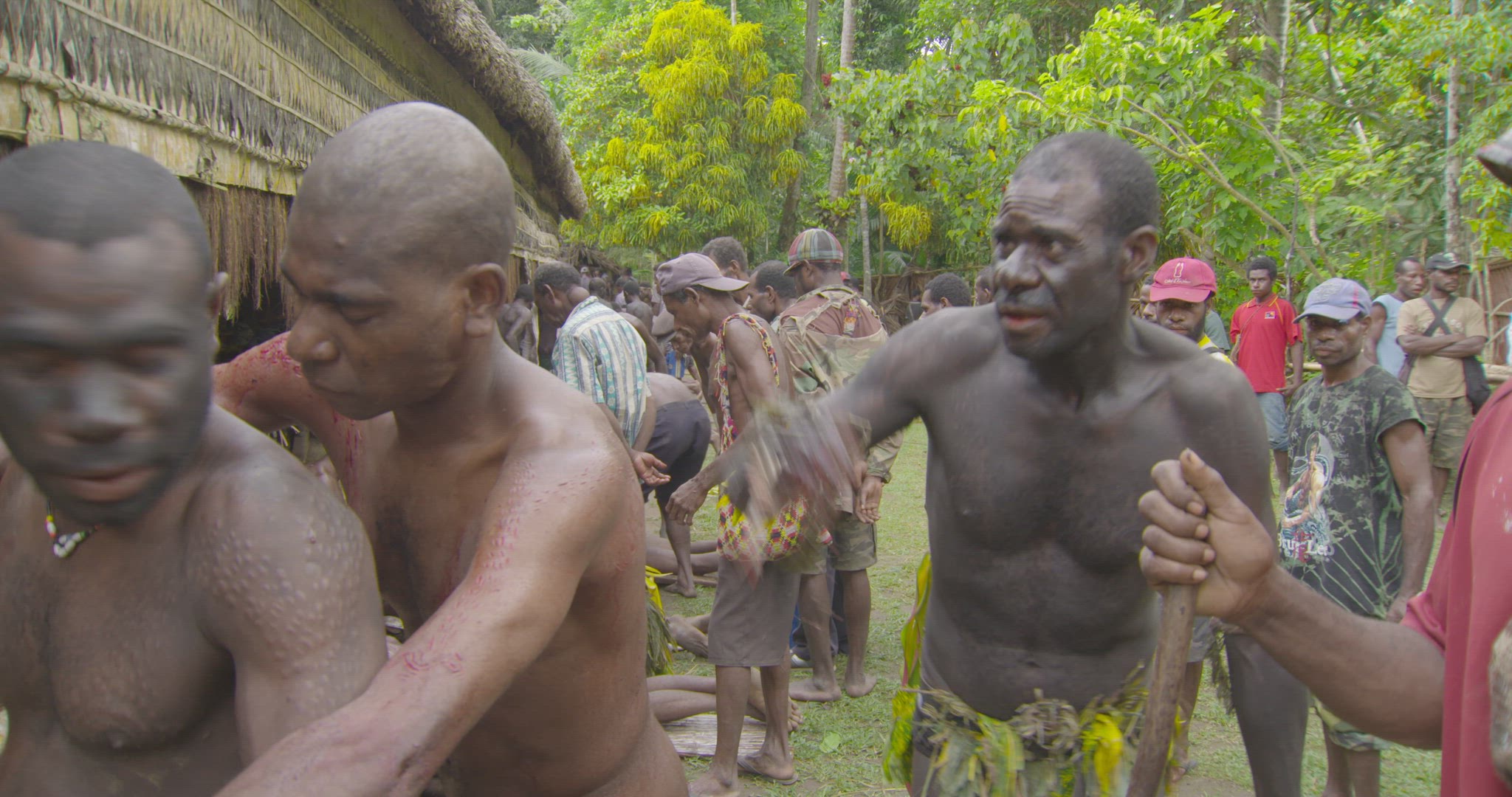 men entering spirit house after scarification skin cutting ritual