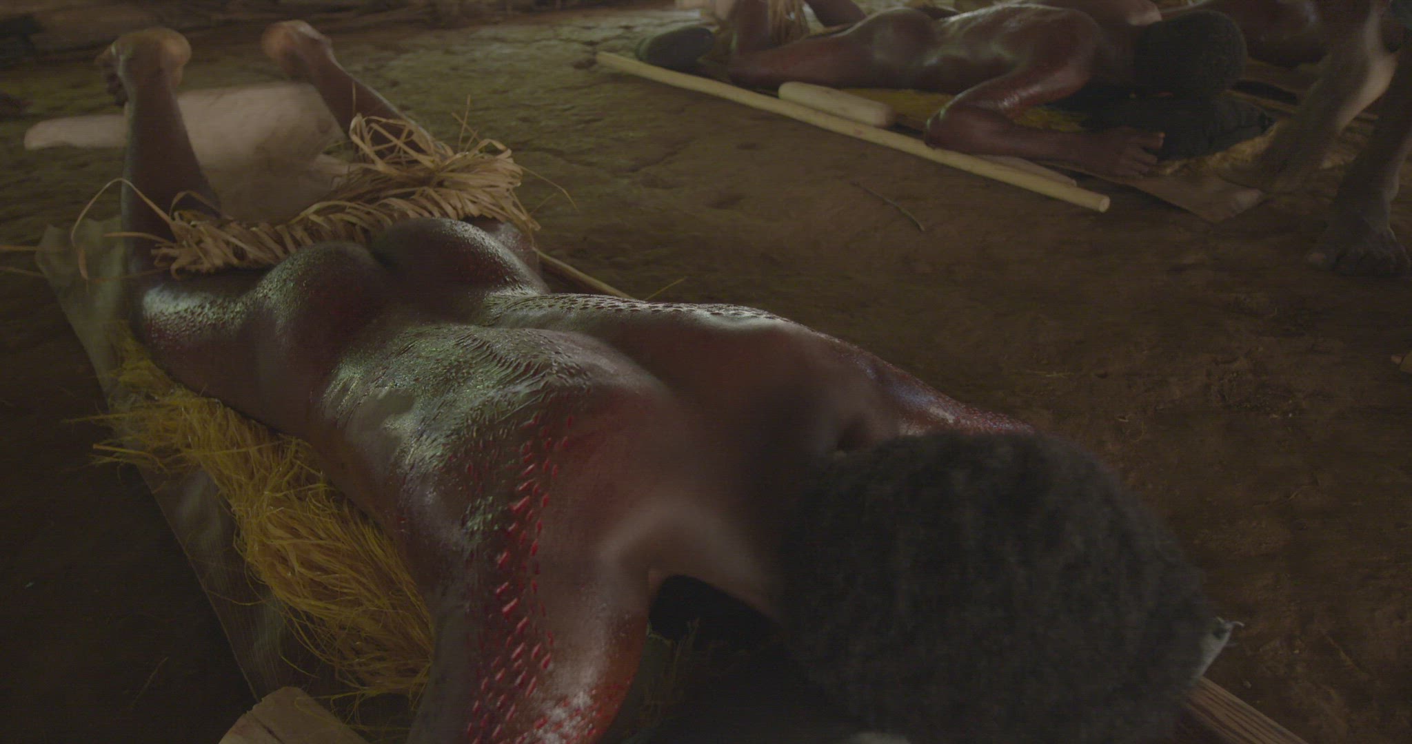 men laying on stomach after skin cutting ritual