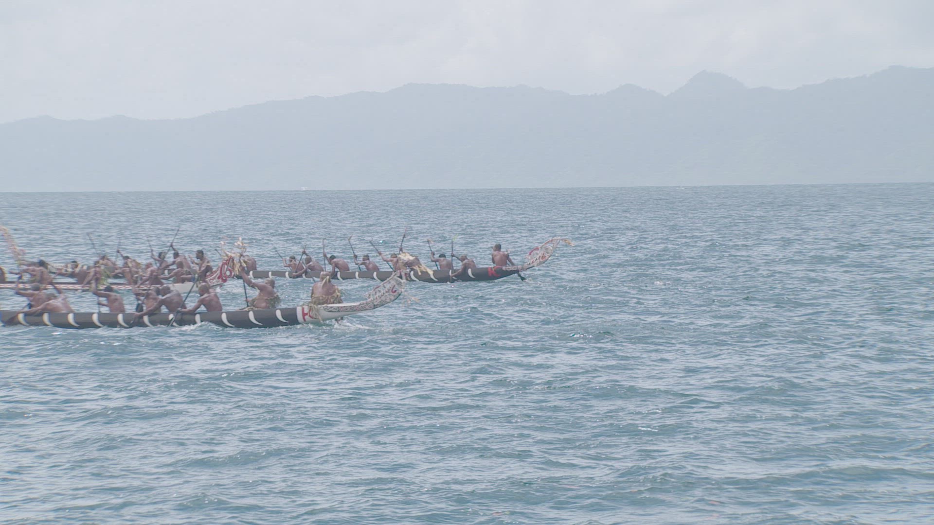 war canoe being paddled on water