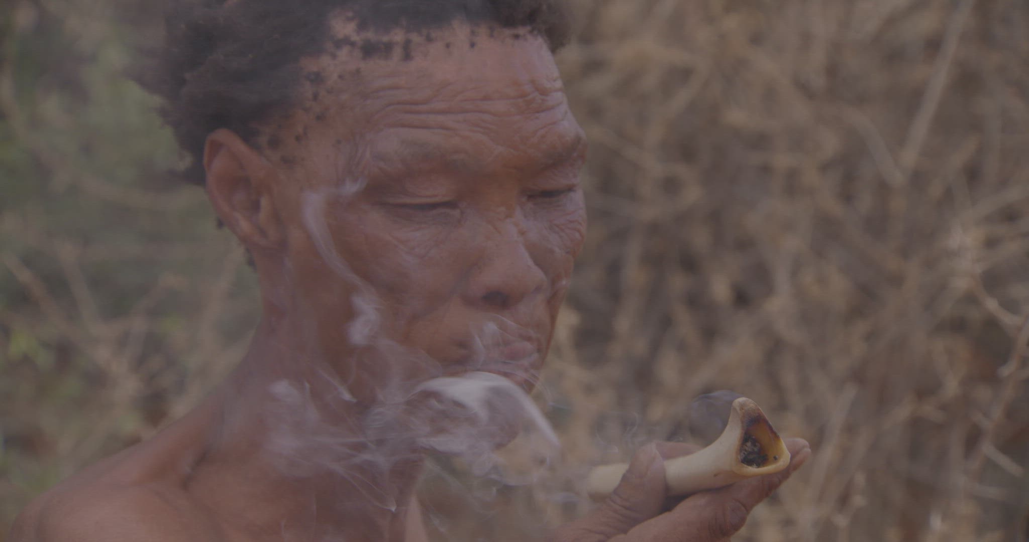 woman smoking through animal bone