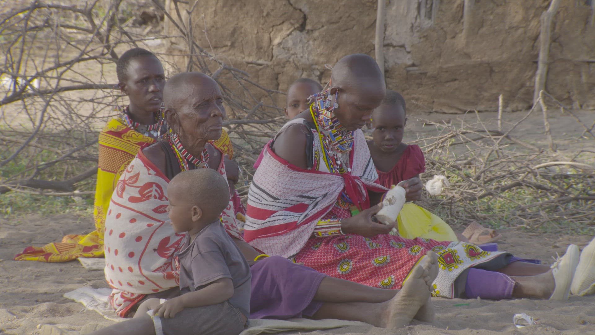 women sitting together beading jewelry