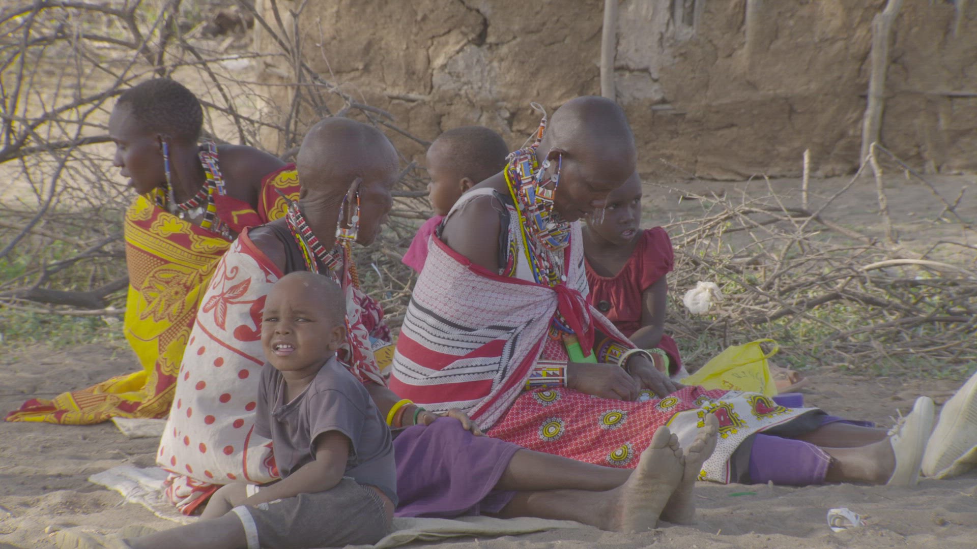 women sitting together beading jewelry