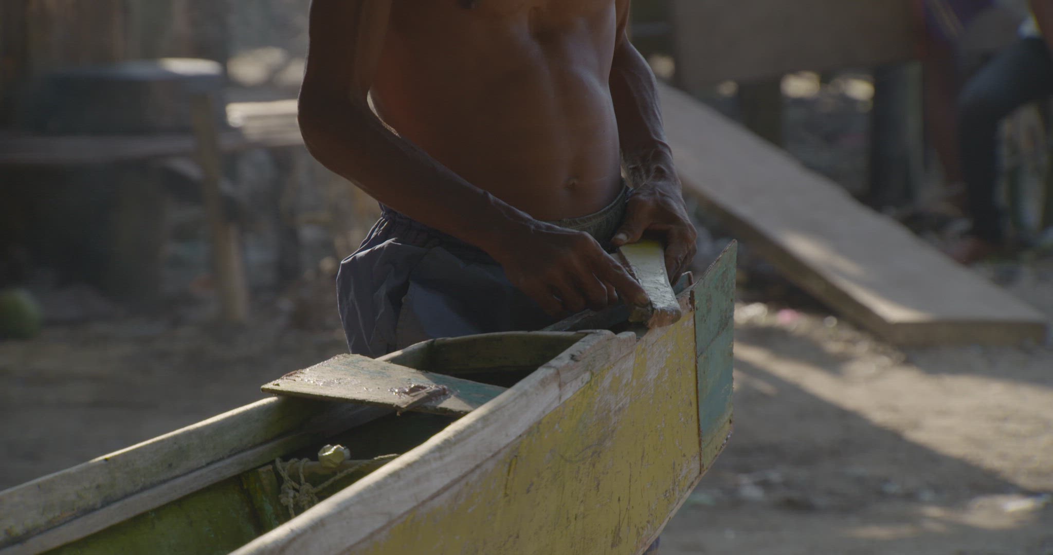 man repairing outrigger boat