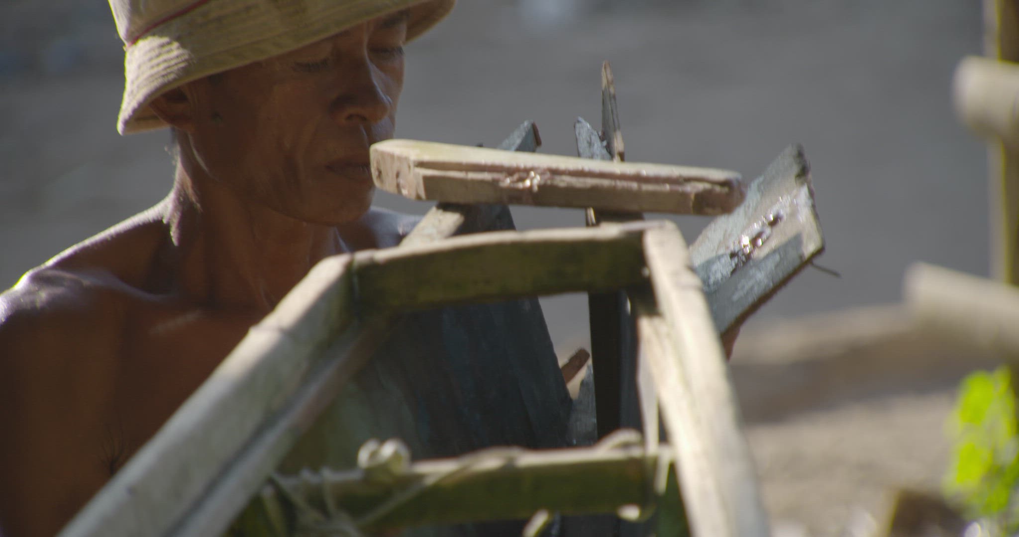 man repairing outrigger boat