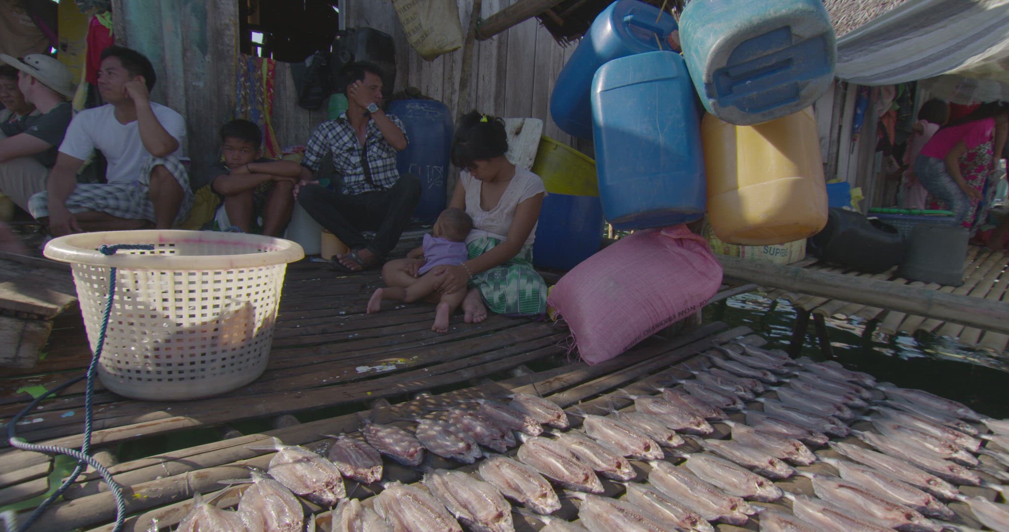 woman laying out fish fillets to be sun dried