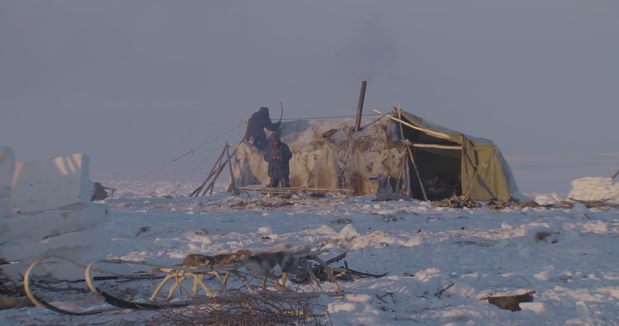 two people preparing reindeer hut