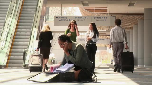 Business traveler searching through clothes on airport floor