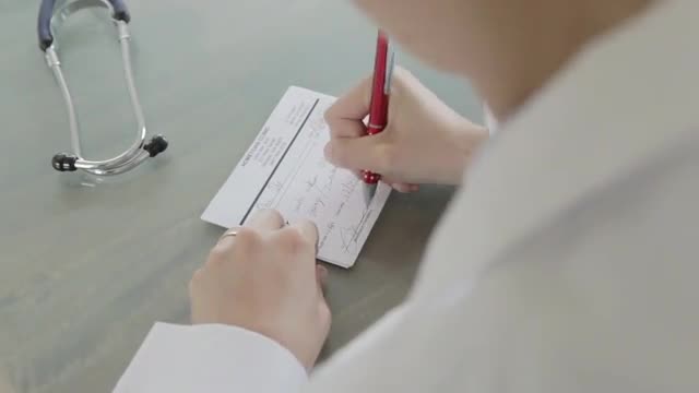Caucasian doctor writing a prescription