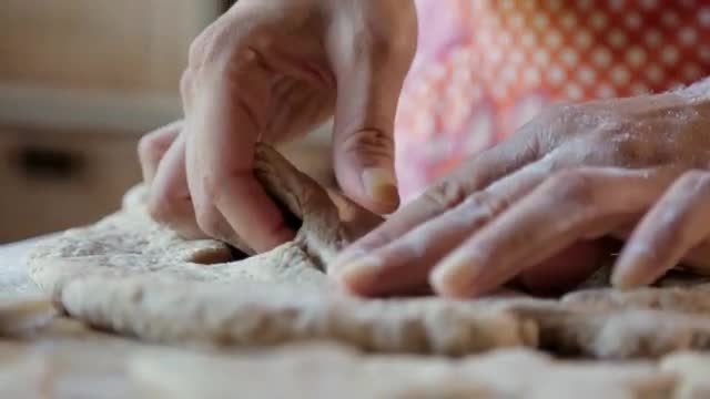 Hispanic woman pressing star shapes in dough