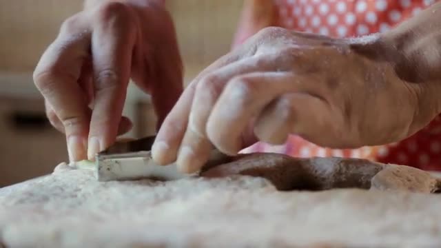 Hispanic woman pressing star shapes in dough