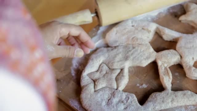 Hispanic woman pressing star shapes in dough