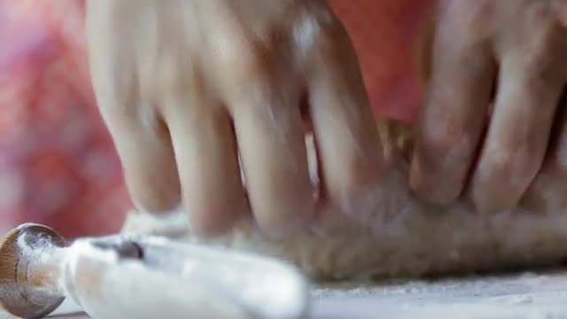Hispanic woman kneading dough