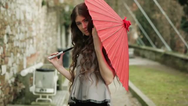 Fashion Model With Long Curly Hair Poses With Traditional Red Japanese Umbrella