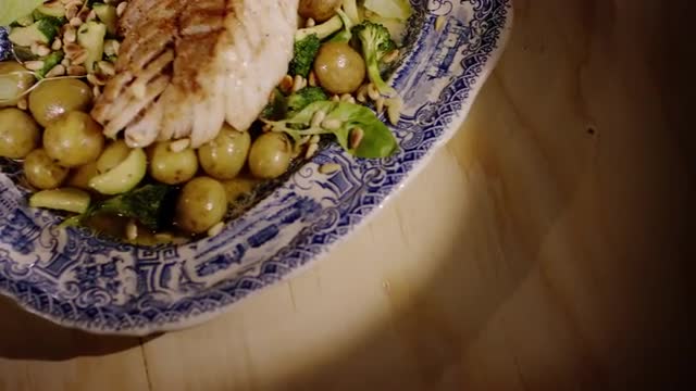 Healthy dish, grilled cod with vegetables and pine nuts