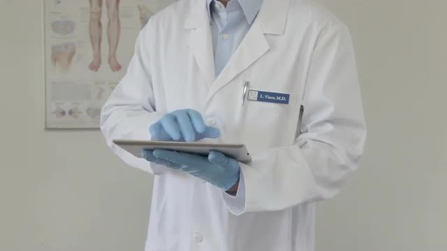 Caucasian doctor typing on digital tablet