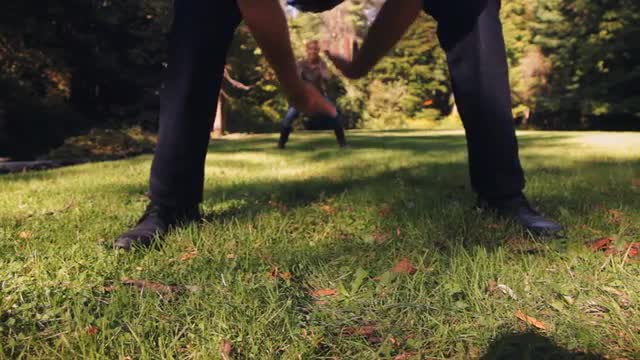 Couple playing American football in field