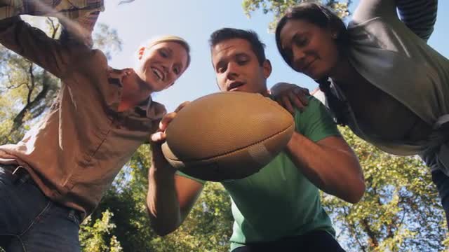 Friends planning strategy in American football huddle