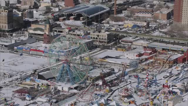 AERIAL MEDIUM WIDE view of Coney Island and reveal Downtown Manhattan in the distance