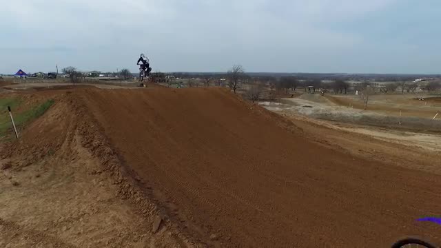 Motocross riders jump a tabletop style jump