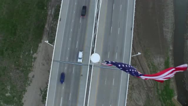 The Texas State Flag and The Margaret Hunt Hill Bridge over Singleton Boulevard in Downtown Dallas