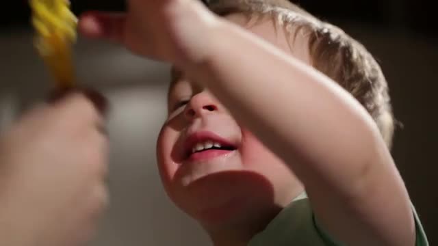 Two year old boy blowing soap bubbles.